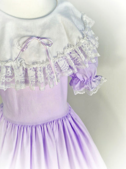 12-14 years. Lilac Lid'l Dolly with white bib, puff sleeves and lace trim