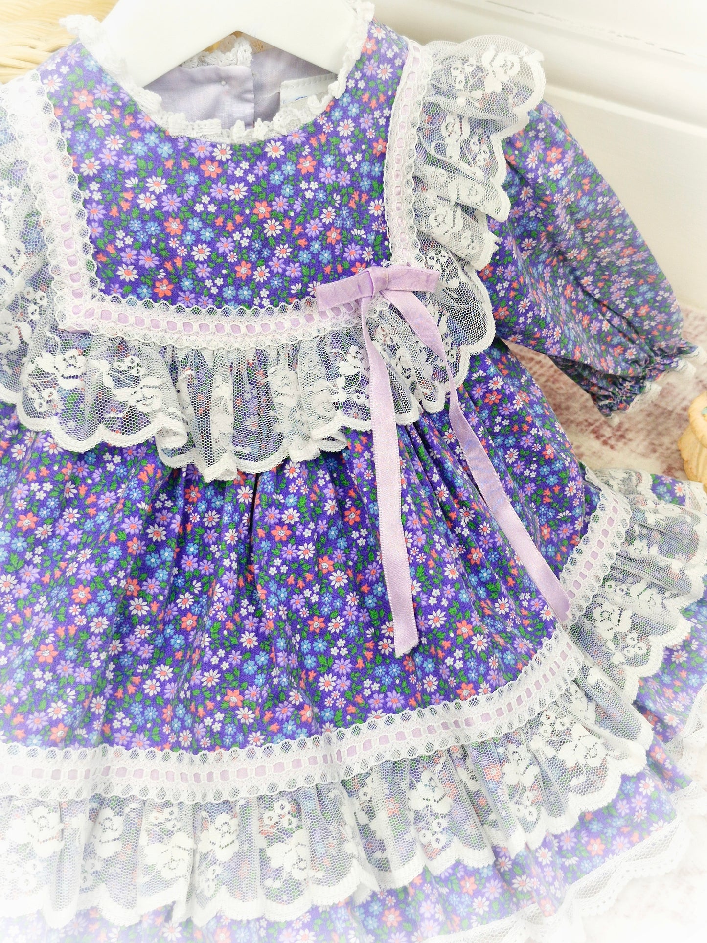 12 months. Purple floral vintage dress by Bryan with white lace details and lilac satin ribbon
