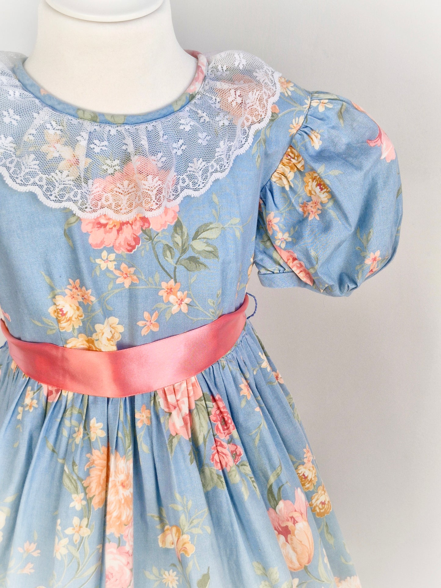 9-10 years. Blue vintage floral dress with pink roses, lace collar, puff sleeves and pink satin waist tie