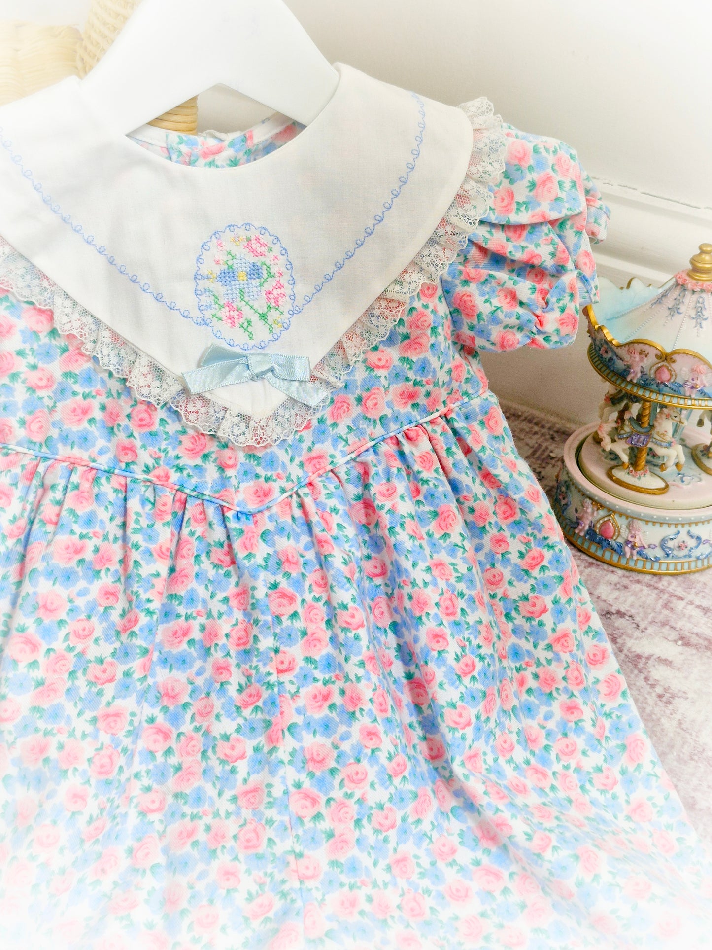 9-12 months. Pink and blue vintage floral romper with white bib and embroidered floral design