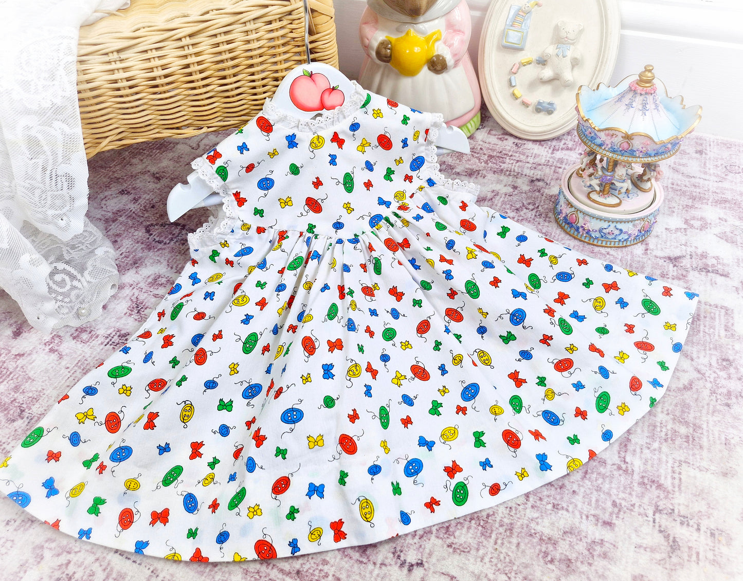 18 months. White sleeveless vintage dress with primary coloured bows and buttons print