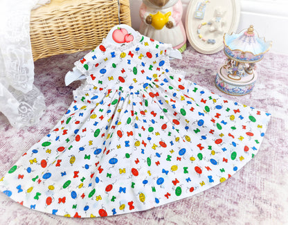 18 months. White sleeveless vintage dress with primary coloured bows and buttons print