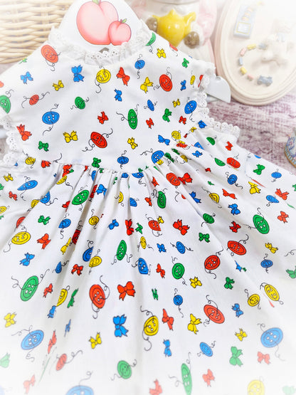 18 months. White sleeveless vintage dress with primary coloured bows and buttons print