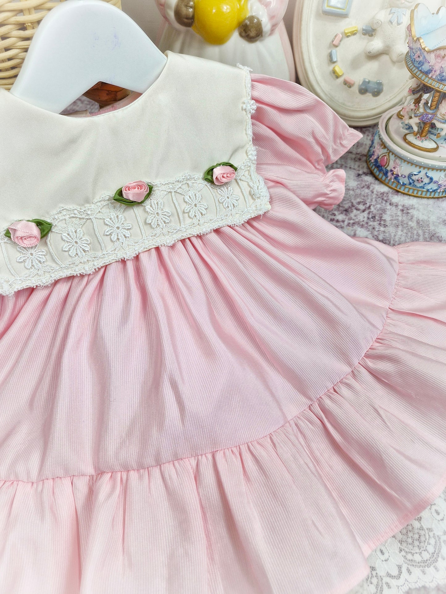 12-18 months. Pink vintage Bryan dress with white bib, lace hem and 3 rosettes