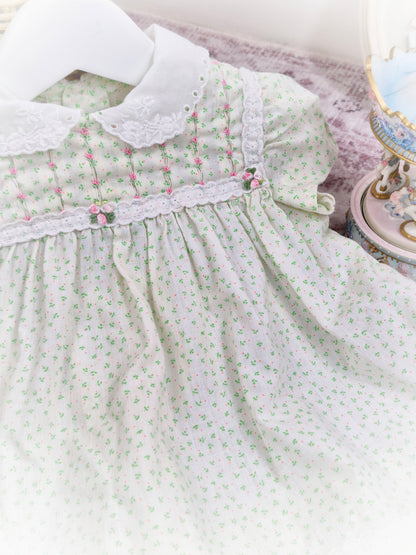 12-18 months. Cream vintage Polly Flinders dress with green and pink print, smocking with pink embroidered flowers and white collar