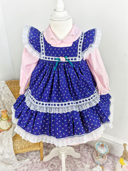 18-24 months/2 years. Two piece vintage set, pink dress with embroidered flowers on collar and navy pinny with floral print. Flutter shoulders and lace details