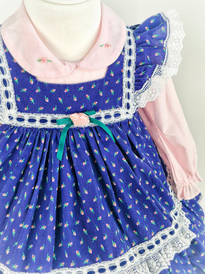 18-24 months/2 years. Two piece vintage set, pink dress with embroidered flowers on collar and navy pinny with floral print. Flutter shoulders and lace details