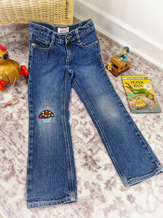5 years. Oshkosh jeans with cupcake applique on the knee