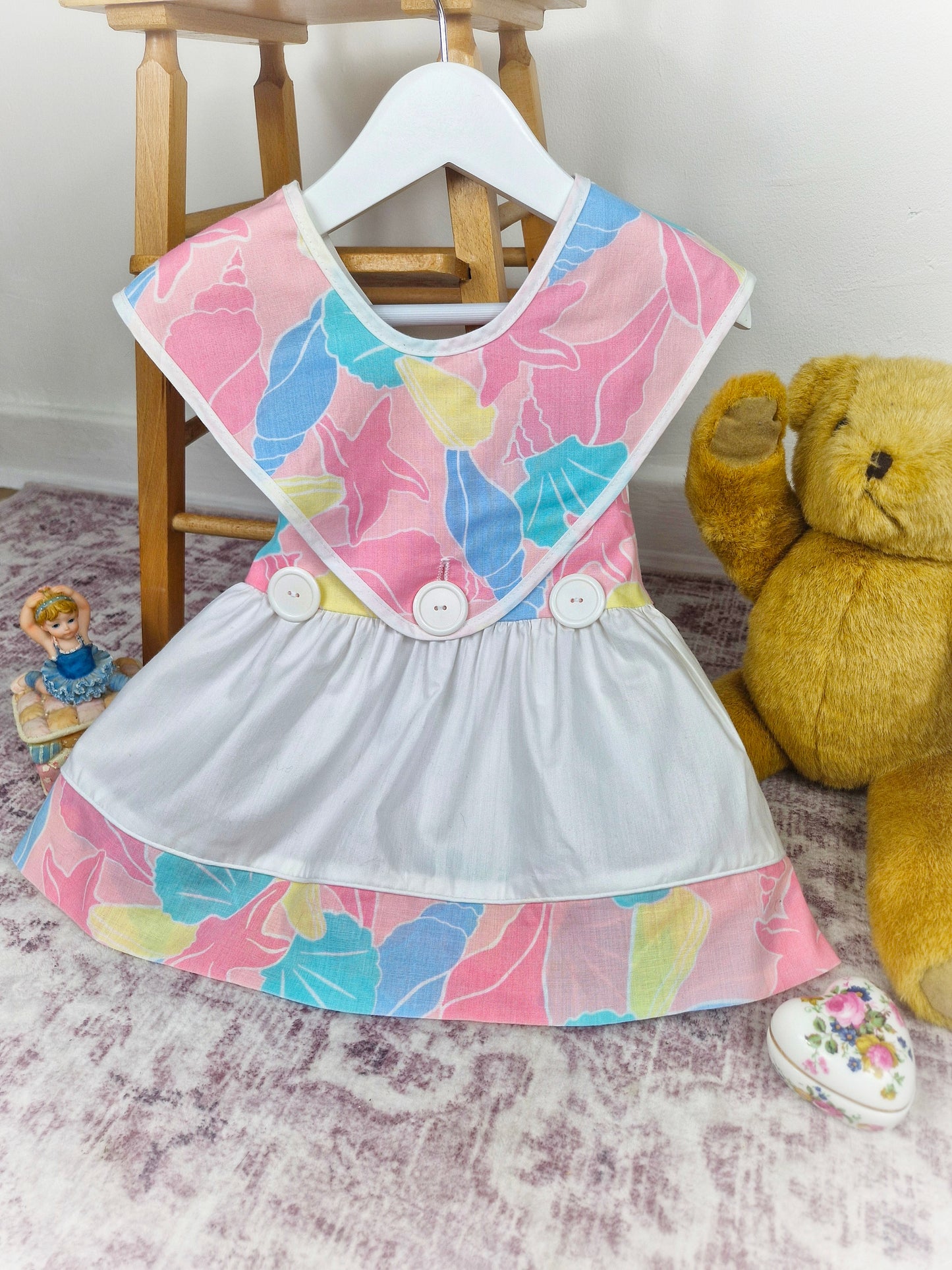 18-24 months. White vintage dress with colourful shell print, top layer unbuttons for different look!