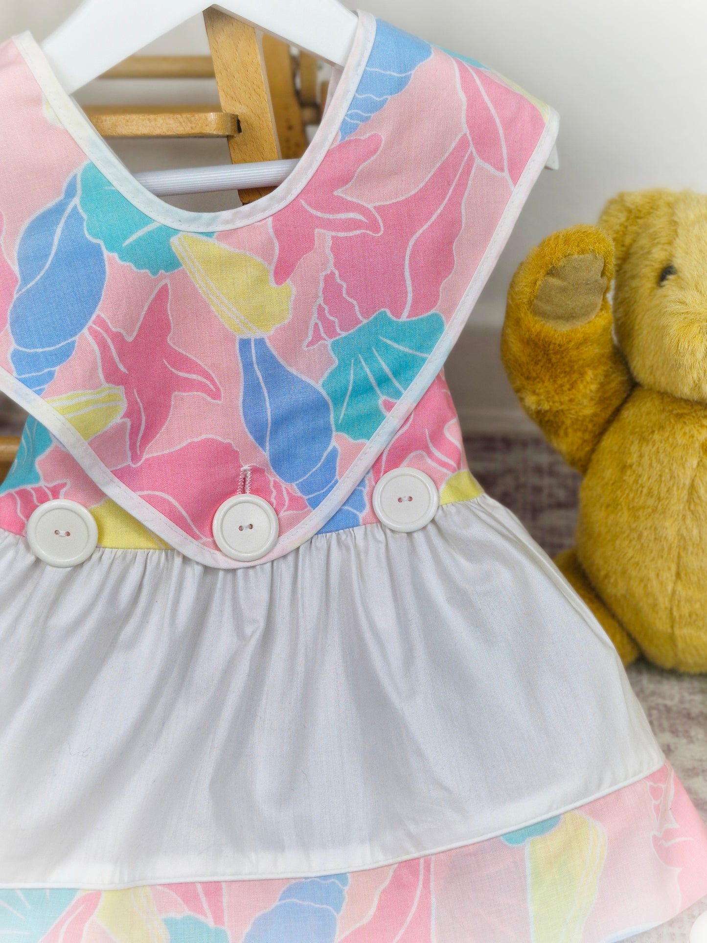 18-24 months. White vintage dress with colourful shell print, top layer unbuttons for different look!