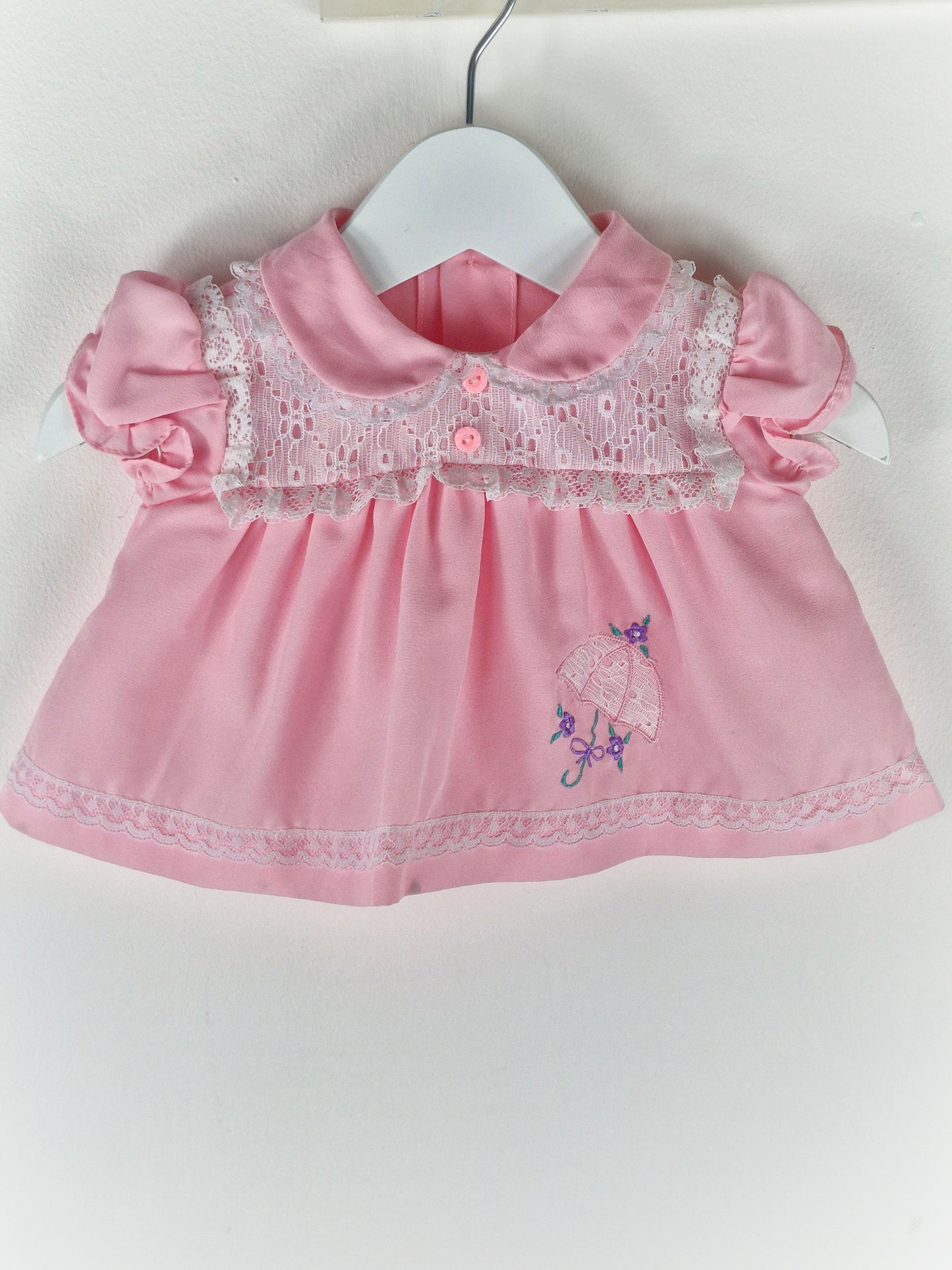 0-3 months. Pink vintage dress with eyelet lace details, puff sleeves and embroidered umbrella