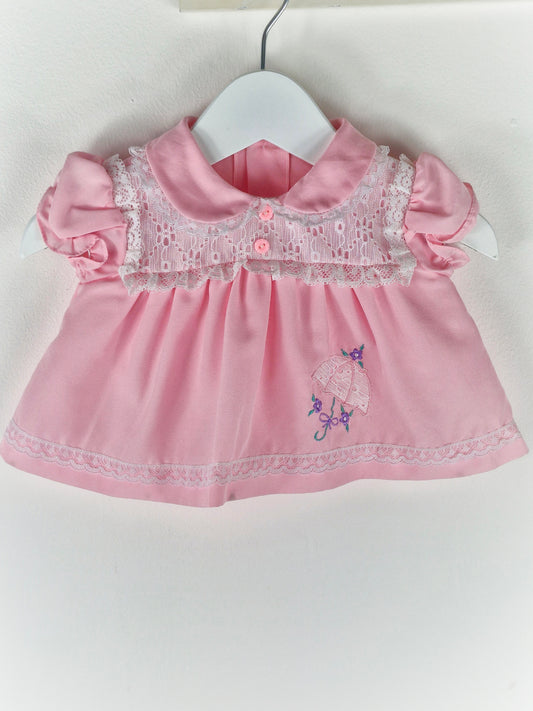 0-3 months. Pink vintage dress with eyelet lace details, puff sleeves and embroidered umbrella