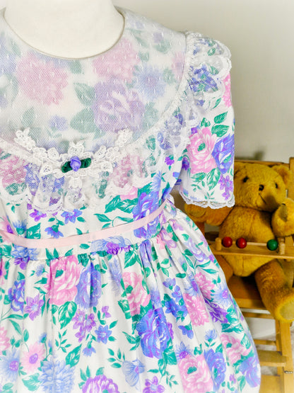 4-5 years. White vintage Celeste dress with pink and purple floral design and large white lace bib