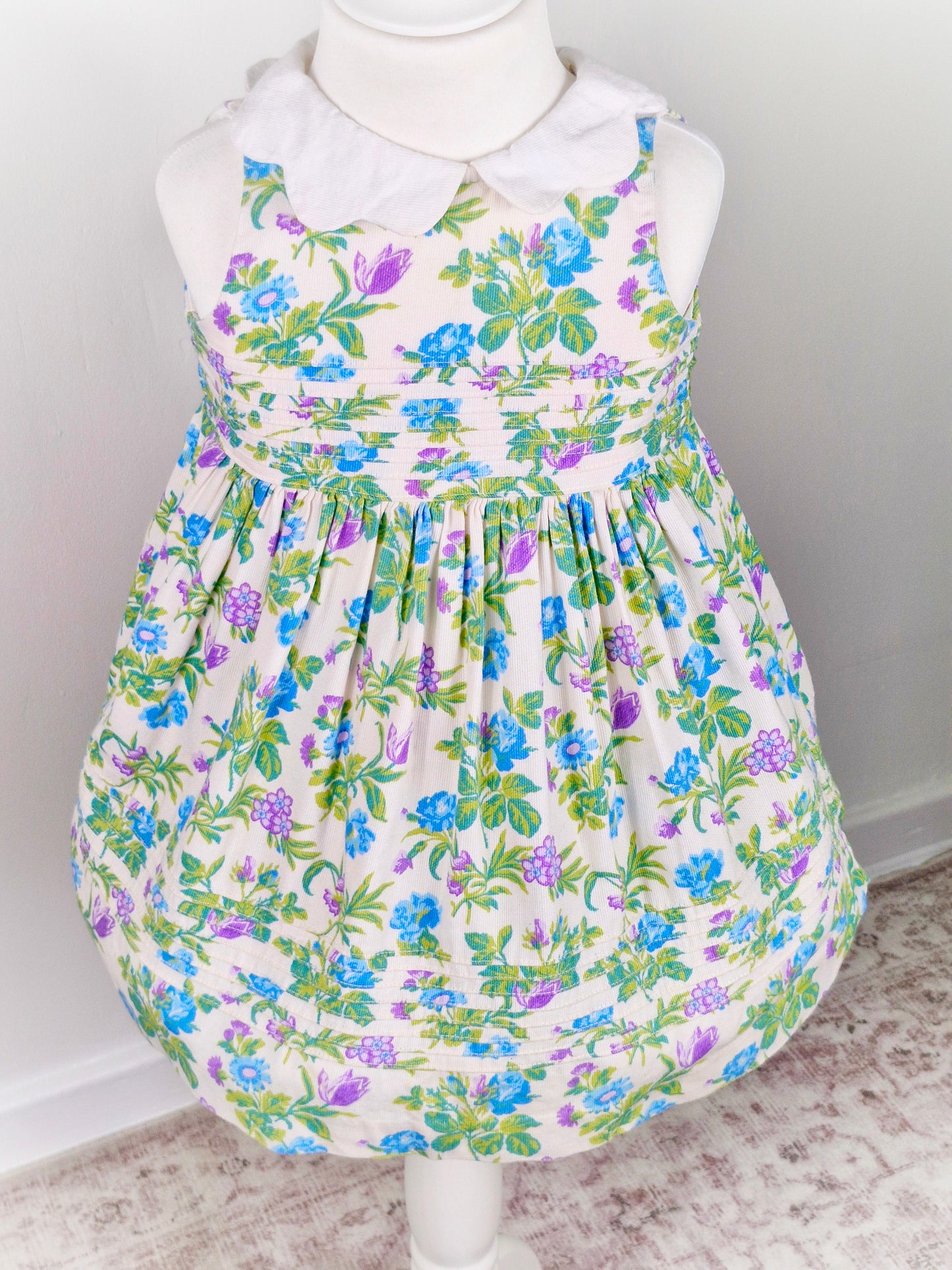 2 years. White sleeveless Laura Ashley dress with floral design and scalloped collar