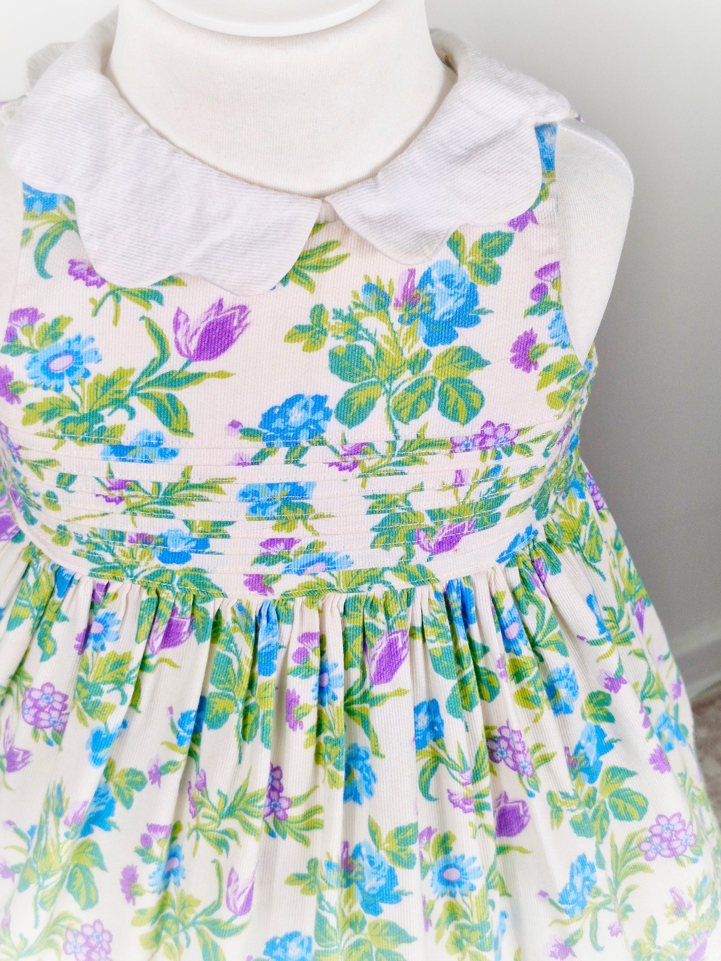 2 years. White sleeveless Laura Ashley dress with floral design and scalloped collar