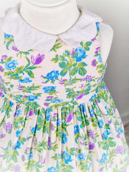 2 years. White sleeveless Laura Ashley dress with floral design and scalloped collar