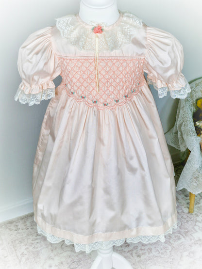 6-7 years. Peach Polly Flinders smock dress embroidered with flowers, with puff sleeves and lace collar