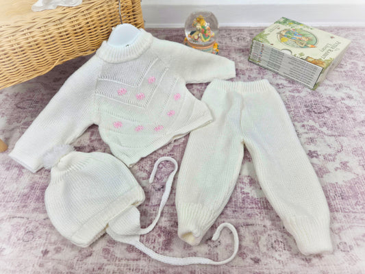6-12 months. Three-piece knit set. White with pink flowers