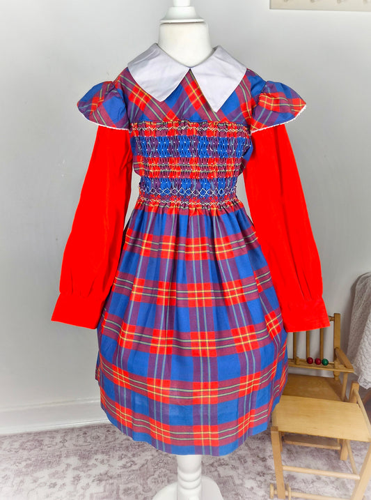 9-10 years. Red and blue tartan smock dress by Polly Flinders with white collar and flutter shoulders