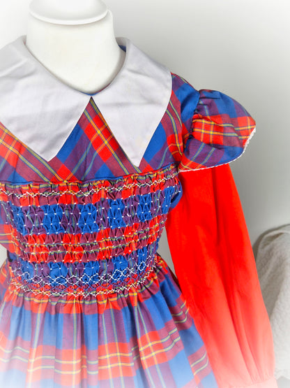 9-10 years. Red and blue tartan smock dress by Polly Flinders with white collar and flutter shoulders