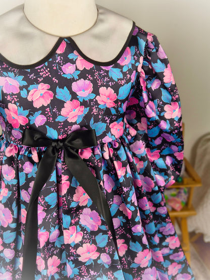 5 years. Black satin vintage dress by Charlianne with pink and blue floral patterns, white collar and black bow