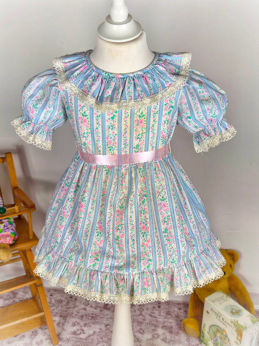 2 years. White vintage dress with blue stripes, pink flowers & belt and lace trim