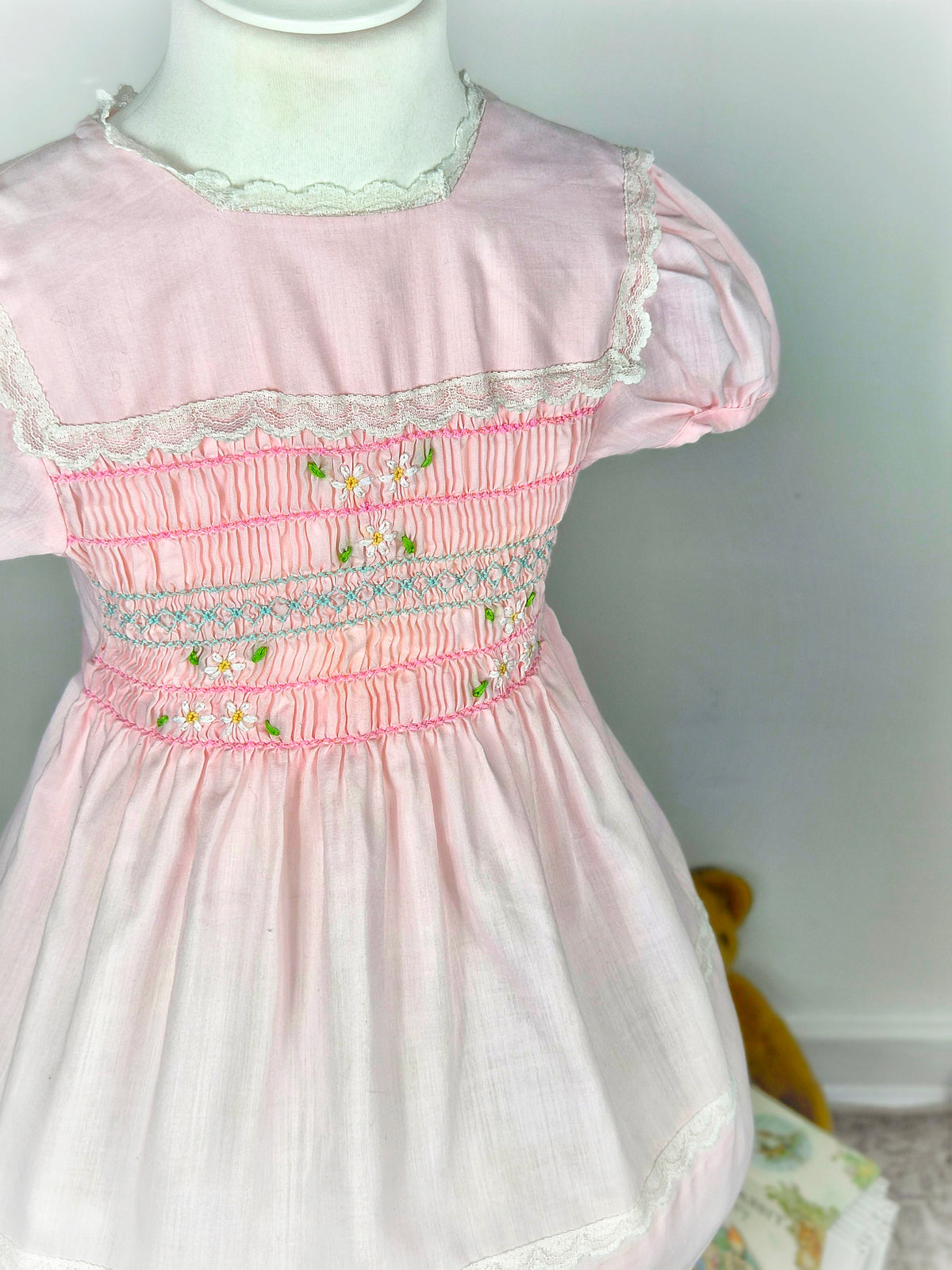 3 years. Pink vintage smock dress from Polly Flinders with white lace trimmed bib and embroidered flowers