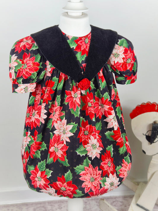 3 years. Black vintage dress with red poinsettia and green leaf festive print, black velour collar and red floral centre