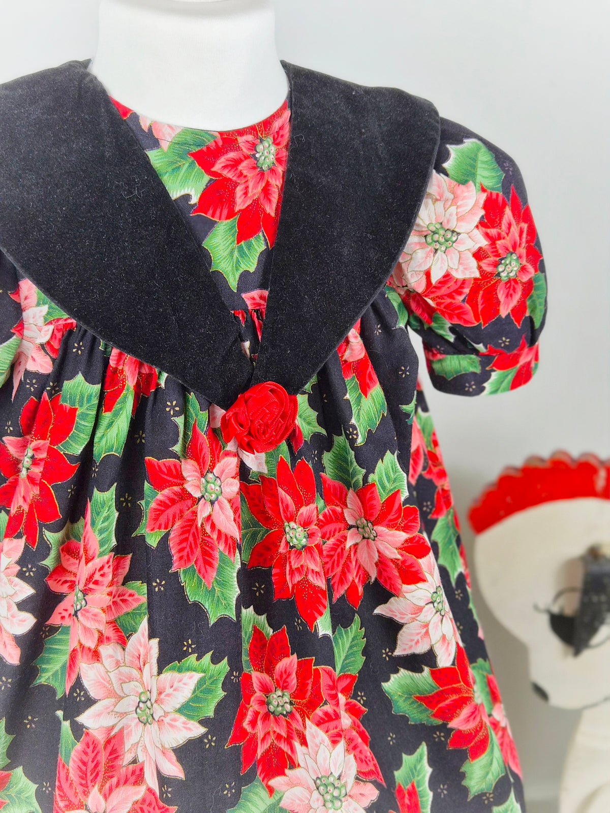 3 years. Black vintage dress with red poinsettia and green leaf festive print, black velour collar and red floral centre