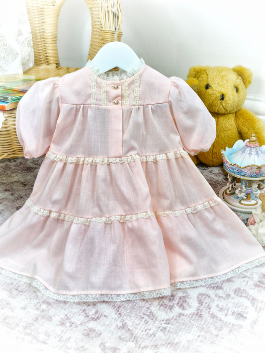 6-12 months. Pale pink Nightie with puff sleeves and cream lace details.