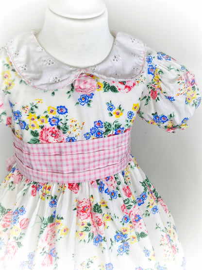 3-4 years. White vintage dress by Thomas with eyelet collar, gingham belt and floral print