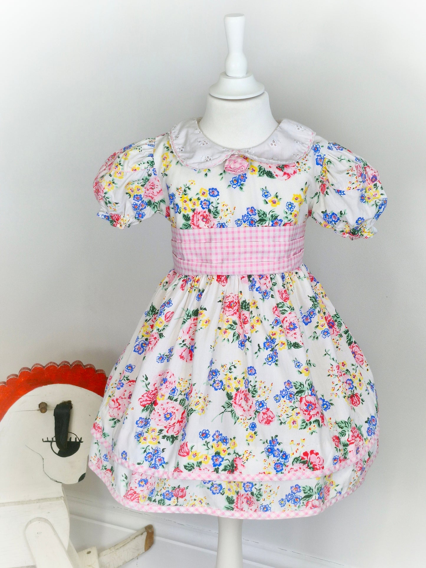 3-4 years. White vintage dress by Thomas with eyelet collar, gingham belt and floral print