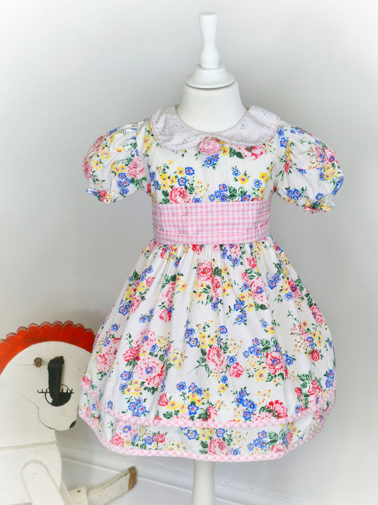 3-4 years. White vintage dress by Thomas with eyelet collar, gingham belt and floral print