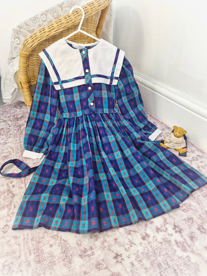 7-8 years. Vintage plaid patterned dress with large white bib, long sleeves and button down front