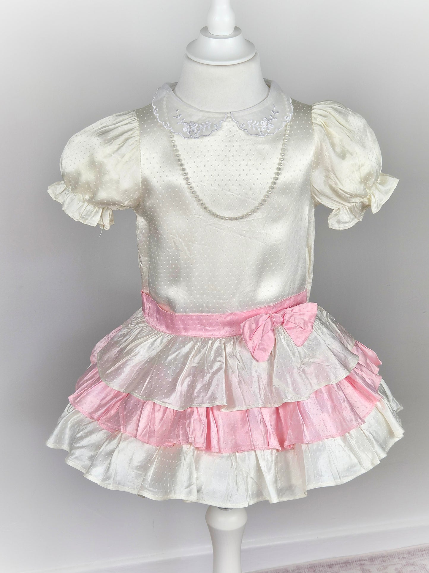 3 years. White satin drop waist vintage dress with pink bow and layers, puff sleeves and pearl faux necklace