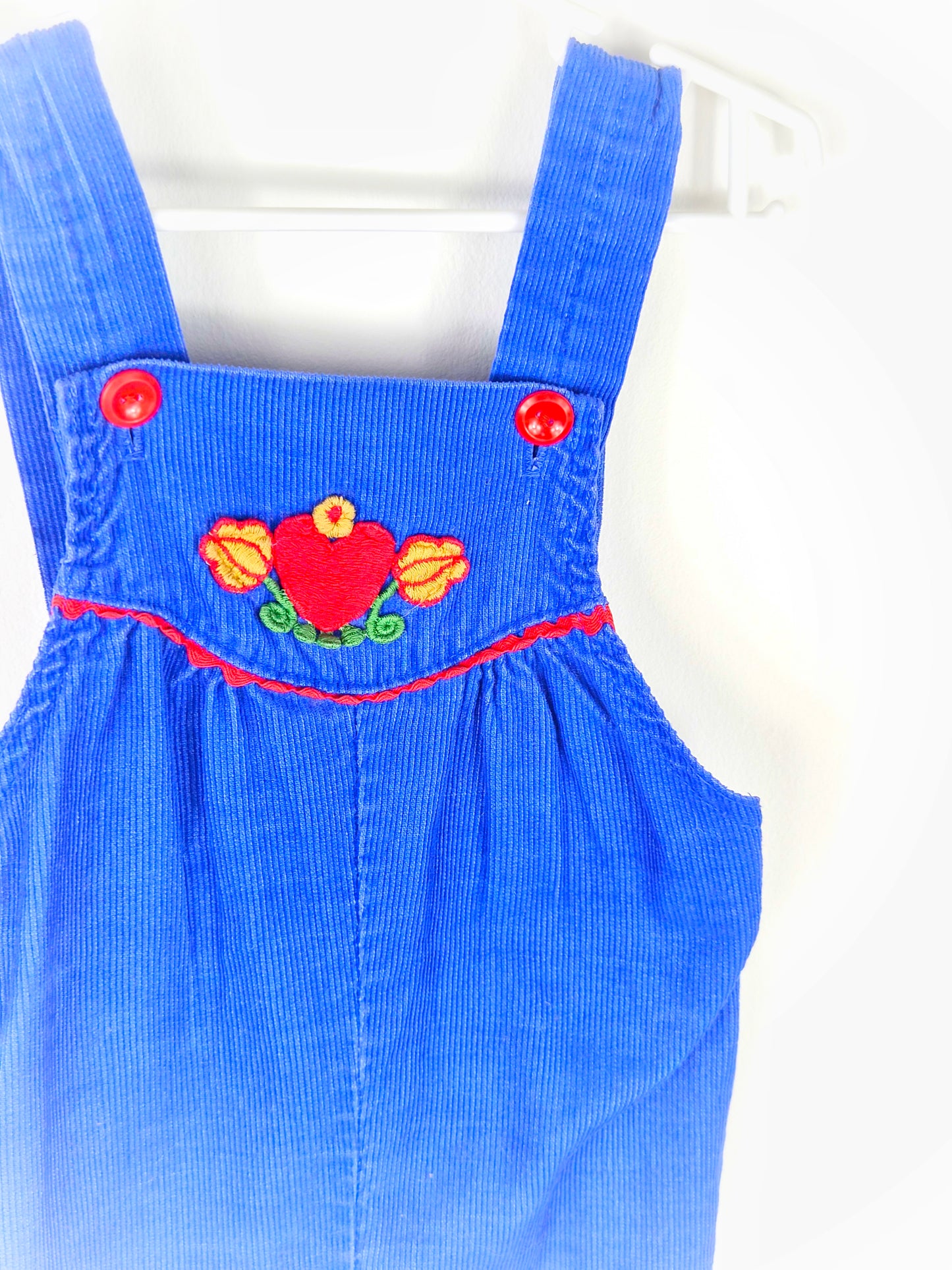 12-18 months. Royal blue corduroy dungarees with red buttons and heart and floral pattern