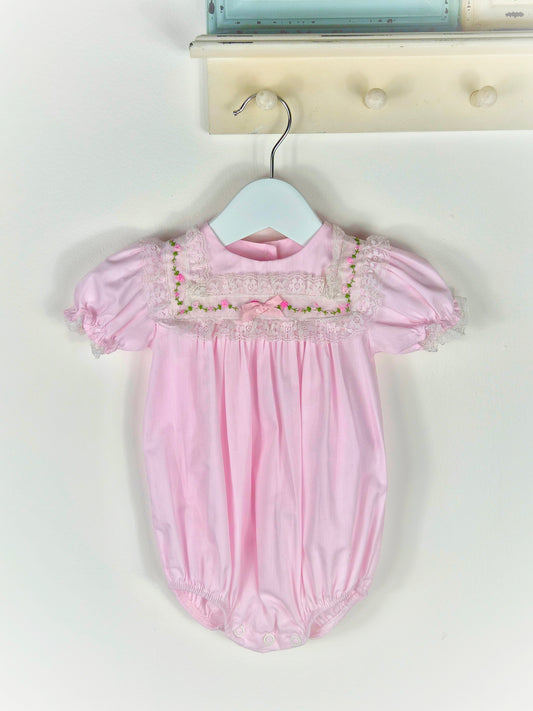 9 months. Pink vintage Alexis romper with puff sleeves and embroidered flowers on a lace bib