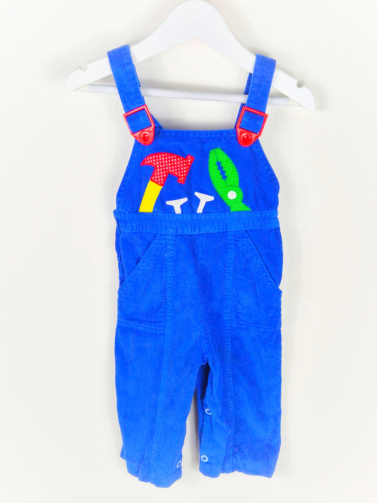 12 months. Blue corduroy dungarees with red adjustable buckles and tools