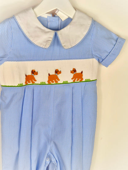 12-18 months. Blue and white gingham smocked romper with embroidered dogs and whi5e collar