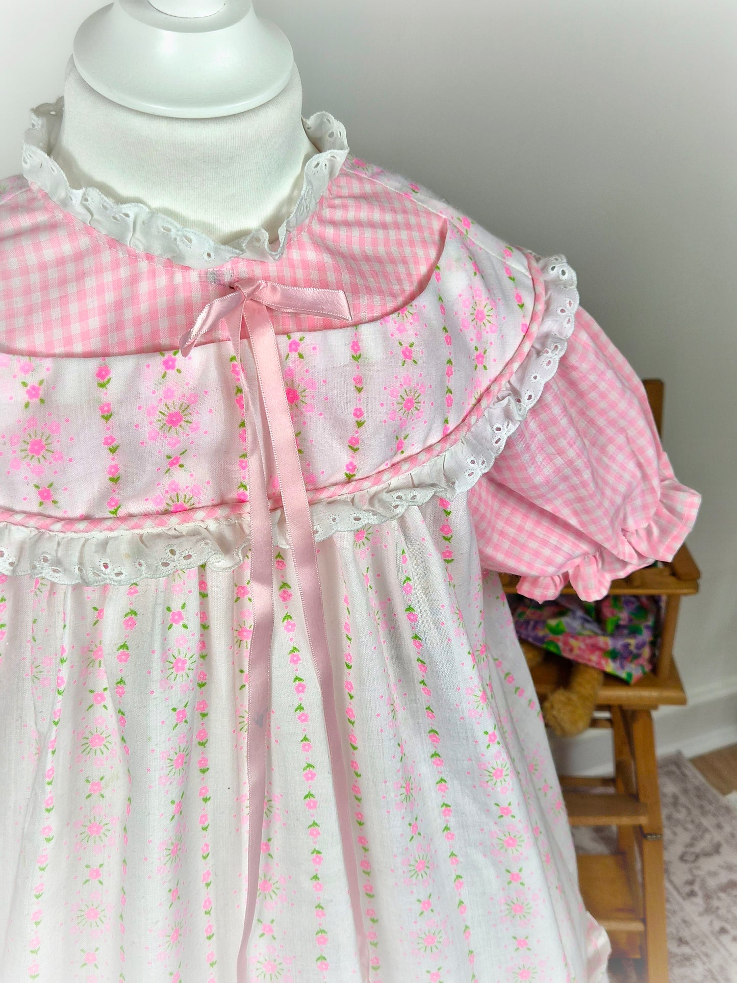 6-7 years. Pink and white gingham dress with floral patterns, pink satin ribbon and puff sleeves