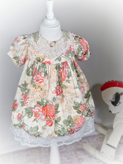 3 years. Cream vintage floral dress with puff sleeves, satin and lace bib and pink rosette