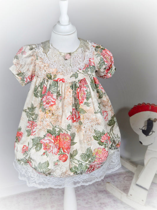 3 years. Cream vintage floral dress with puff sleeves, satin and lace bib and pink rosette
