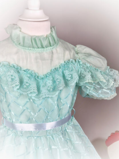 4-5 years. Mint vintage frilly dress with high neck, sheer chest and white ribbon
