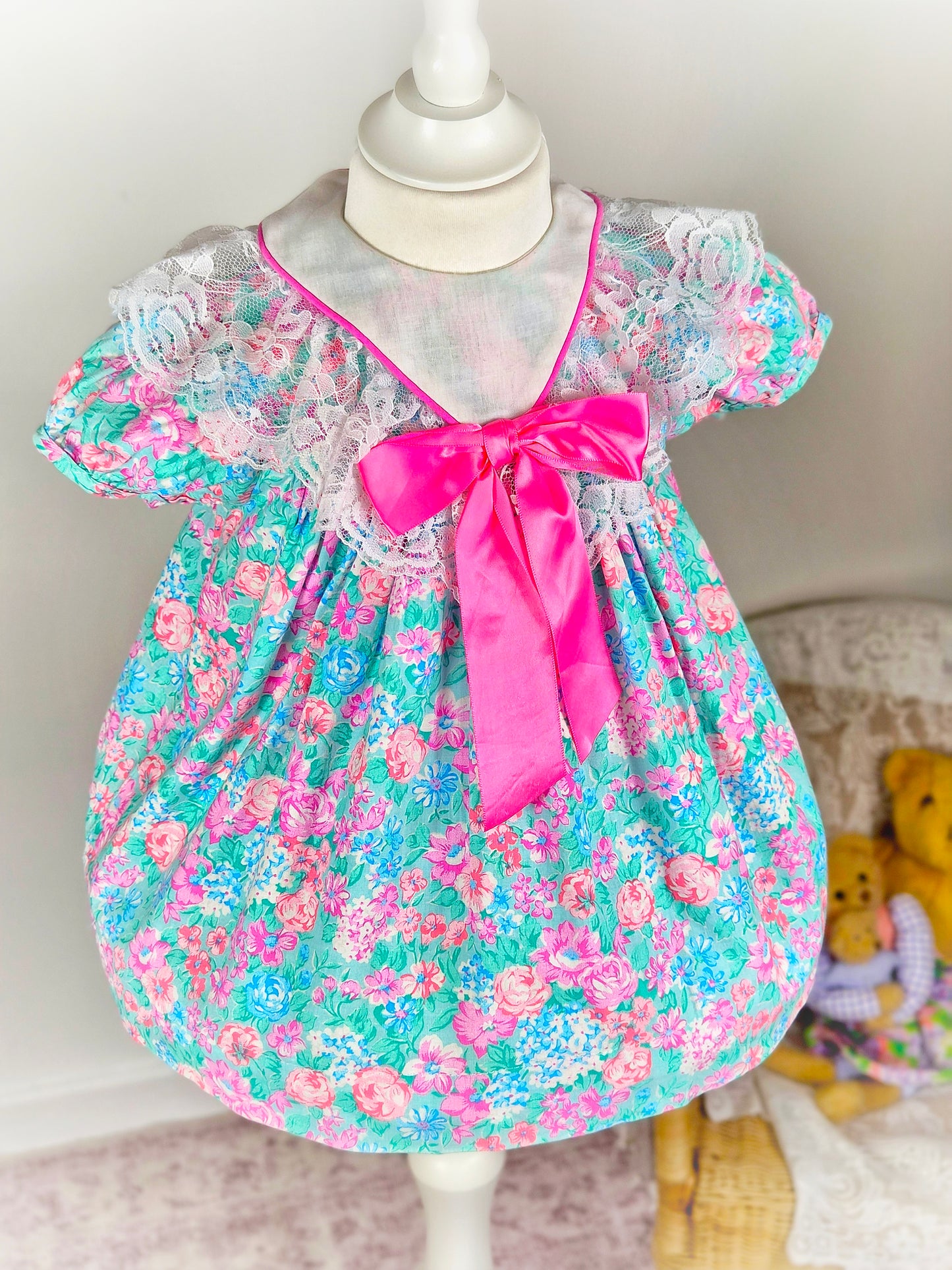 18-24 months. Bright floral vintage dress with white bib and large hot pink satin bow
