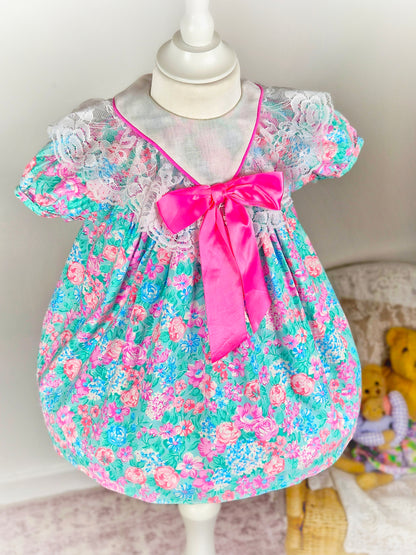18-24 months. Bright floral vintage dress with white bib and large hot pink satin bow