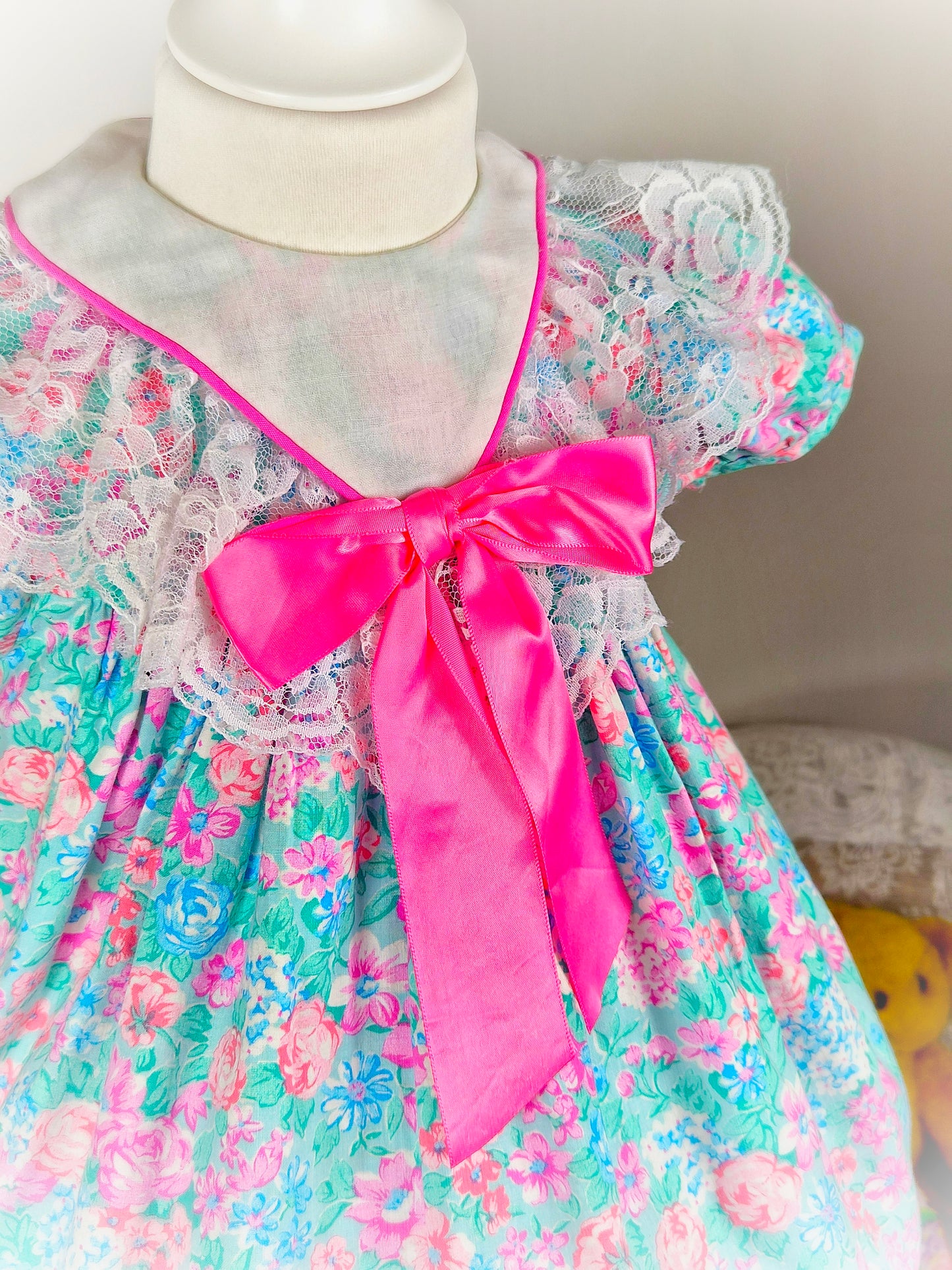 18-24 months. Bright floral vintage dress with white bib and large hot pink satin bow