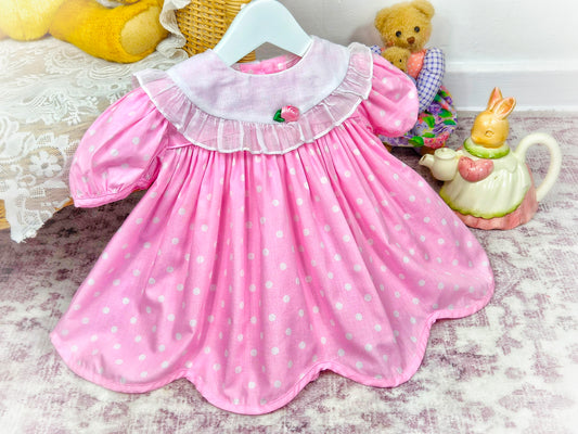 9-12 months. Pink vintage dress with white polka dots, bib, puff sleeves and rosette. Ruth of Carolina