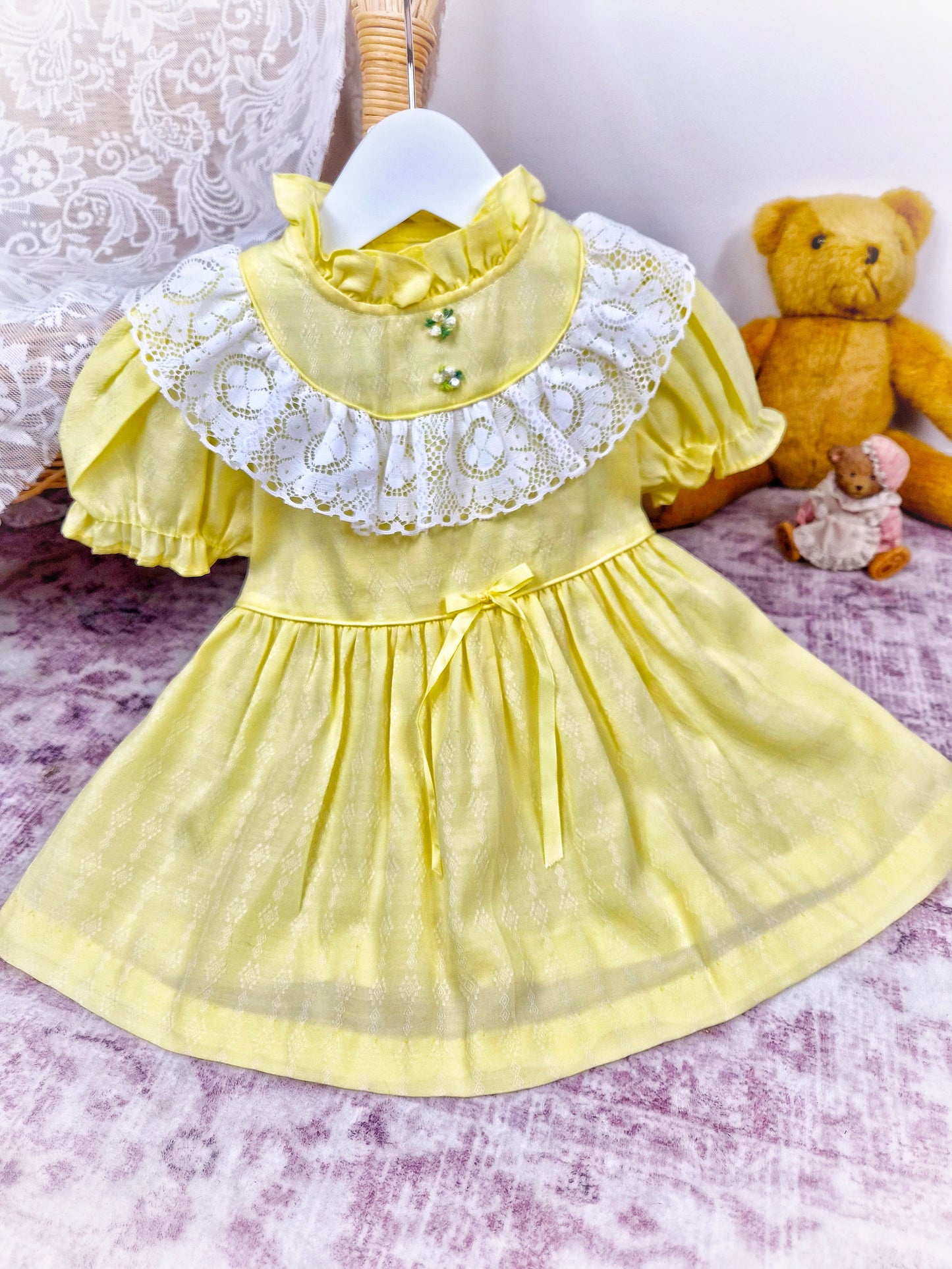 12-18 months. Lemon vintage dress by Toddle Time with white lace details across chest, ruffle neck and puff sleeves
