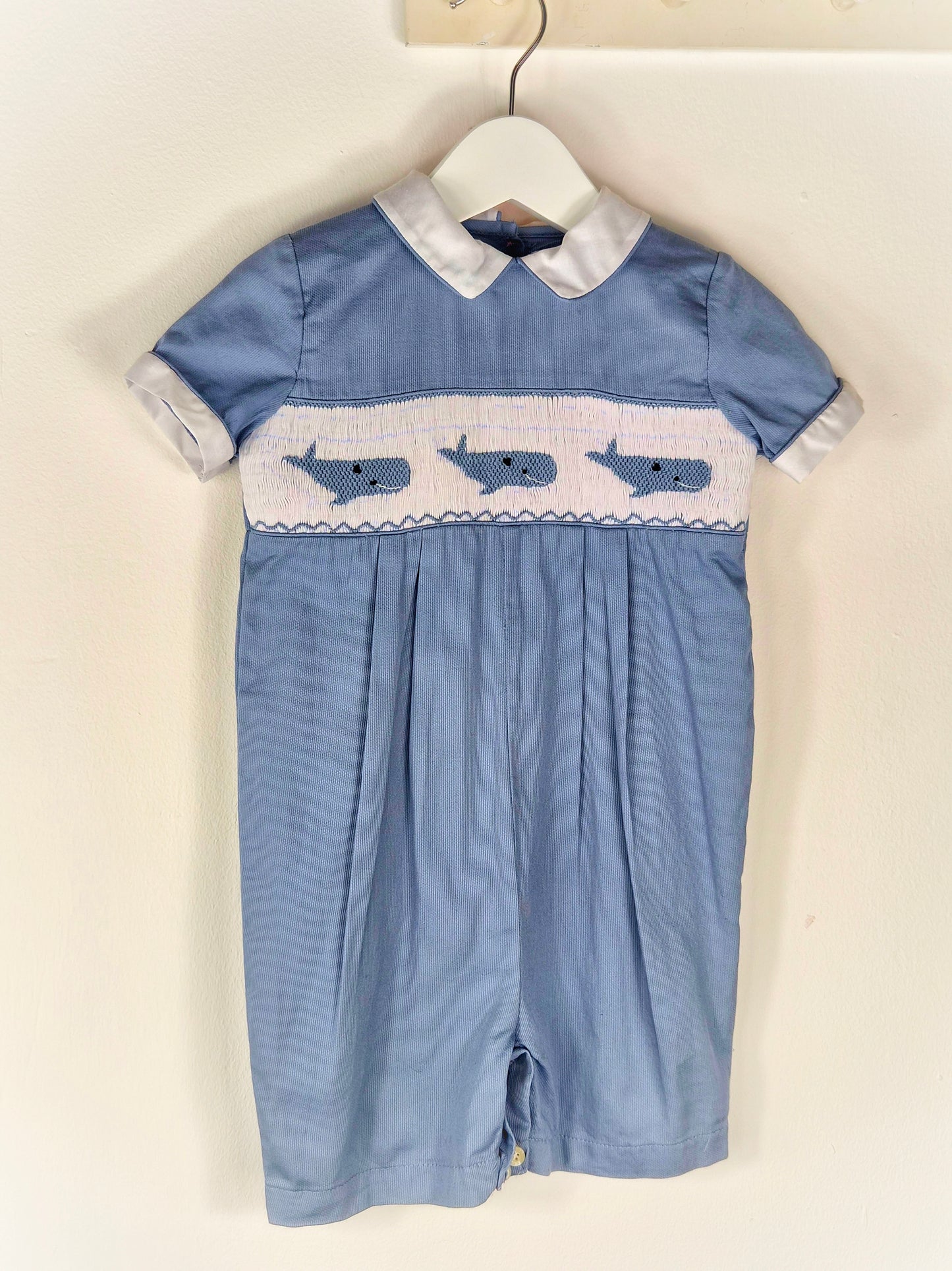 12-18 months. Blue smocked romper with embroidered whales and white peter pan collar