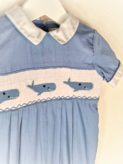 12-18 months. Blue smocked romper with embroidered whales and white peter pan collar